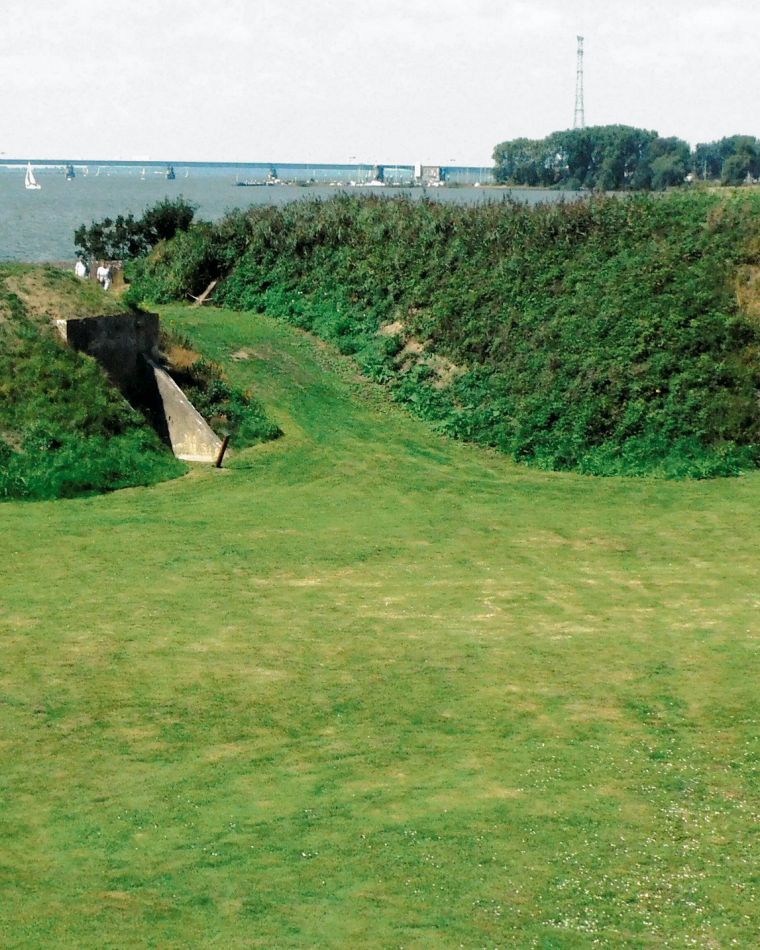 Begroeide wallen en schuilplaatsen op het fortterrein, met de Haringvlietbrug in de verte