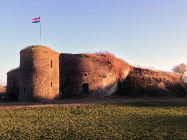 De ronde toren van de bomvrije kazerne met de Nederlandse vlag