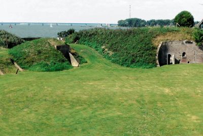 Begroeide wallen en schuilplaatsen op het fortterrein, met de Haringvlietbrug in de verte