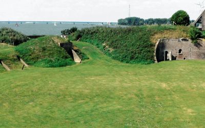 Begroeide wallen en schuilplaatsen op het fortterrein, met de Haringvlietbrug in de verte