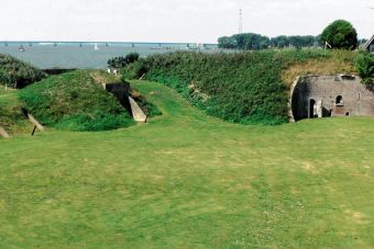 Begroeide wallen en schuilplaatsen op het fortterrein, met de Haringvlietbrug in de verte